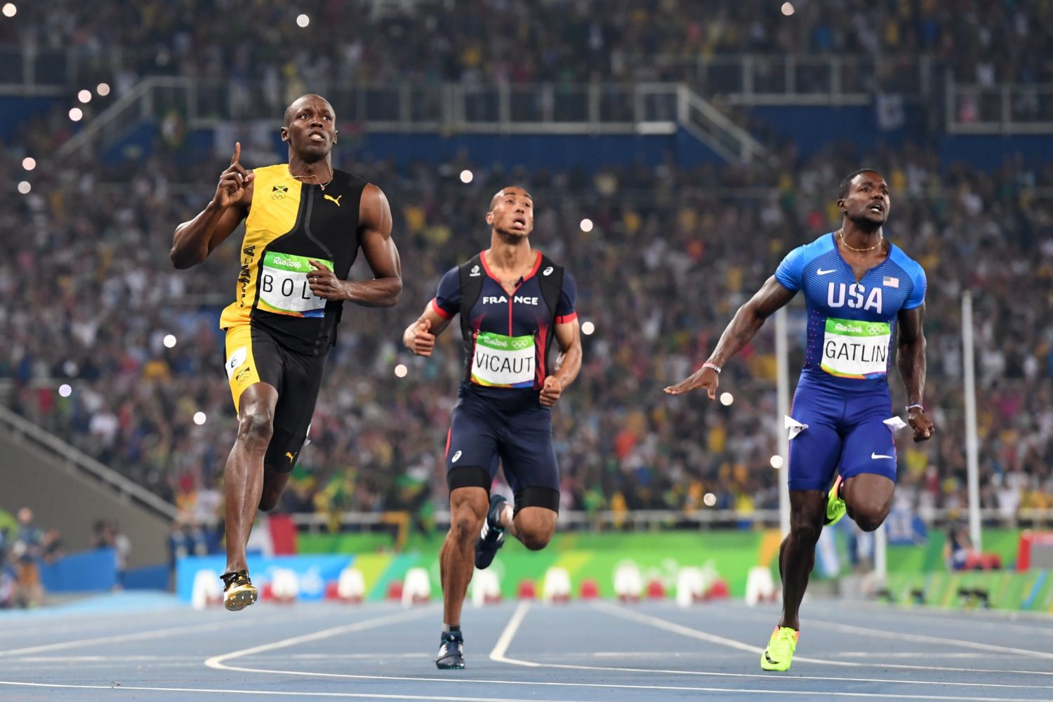 TOPSHOT - Jamaica's Usain Bolt (2ndL) crosses the finish line after he competed with France's Jimmy Vicaut (2ndR) and USA's Justin Gatlin to win the Men's 100m Final during the athletics event at the Rio 2016 Olympic Games at the Olympic Stadium in Rio de Janeiro on August 14, 2016.   / AFP PHOTO / OLIVIER MORIN